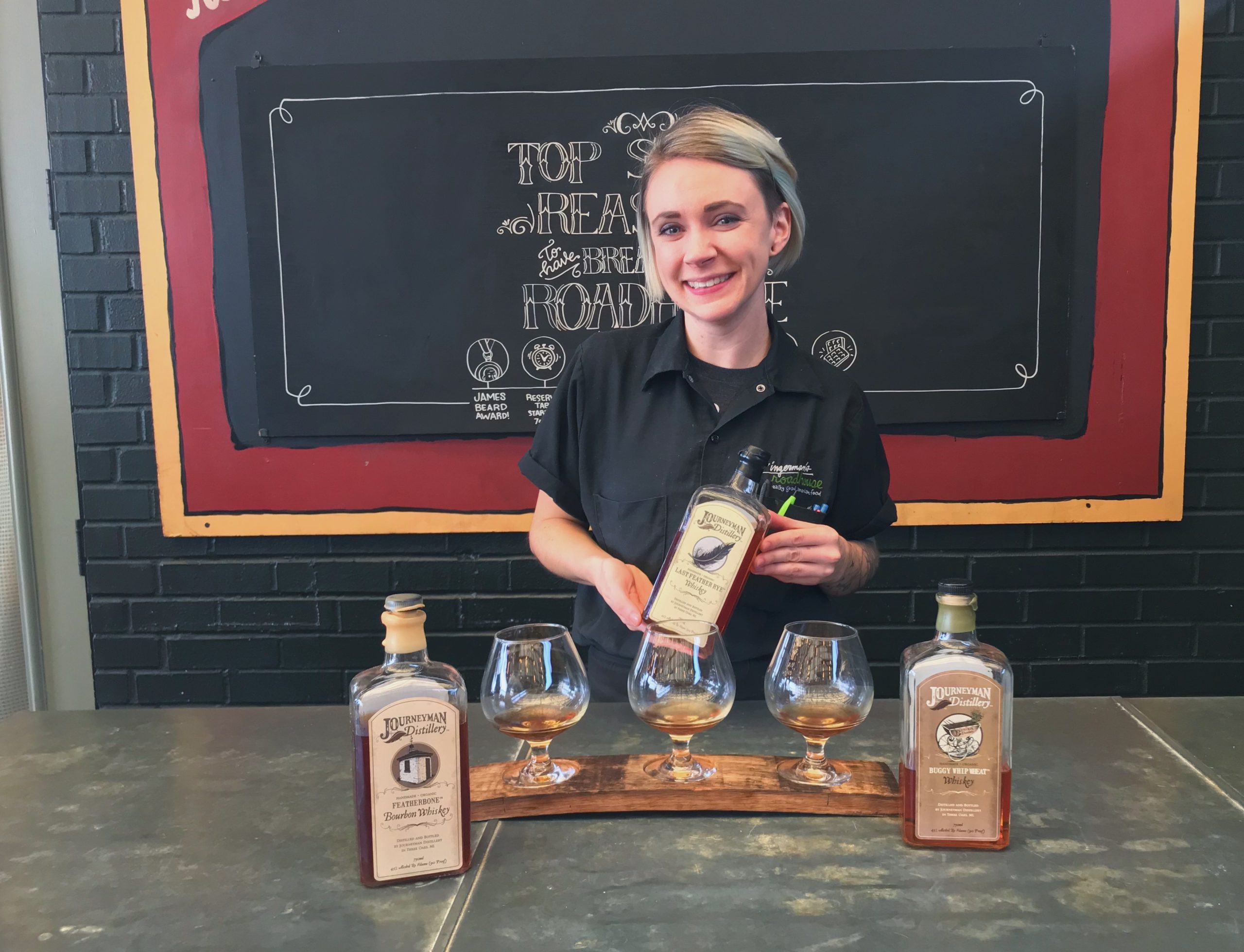 A Zingerman's Roadhouse bartender, Lauren Grant, with the Journeyman Distillery whiskey flight.