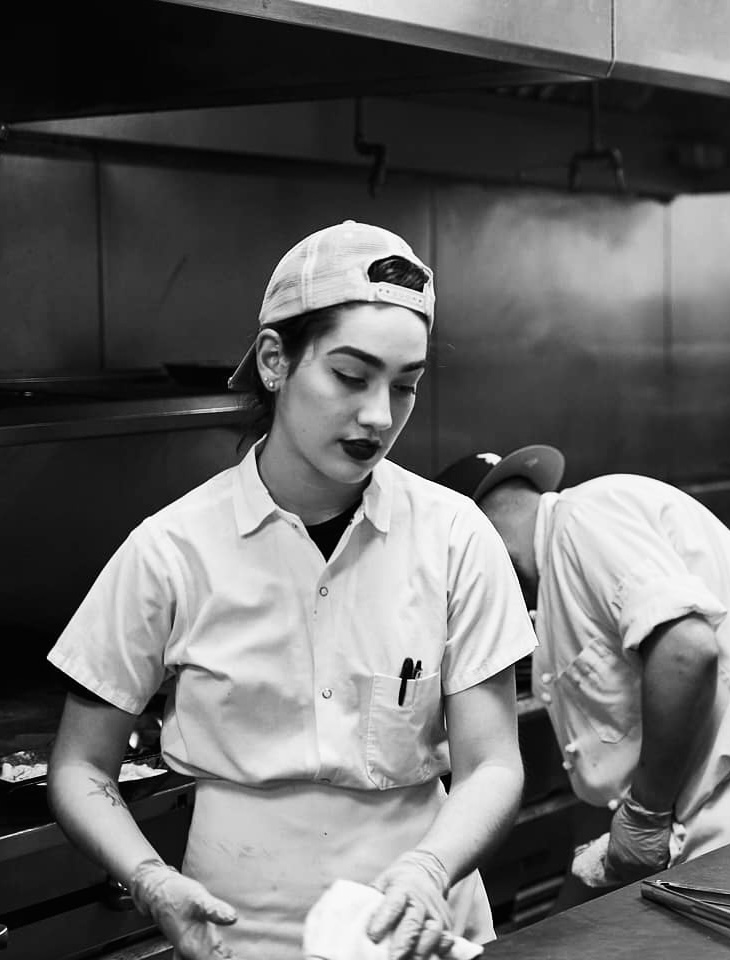 A black and white photo of a Roadhouse staff member cooking.