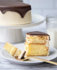 A slice of Boston Cream Pie with a bite on a fork